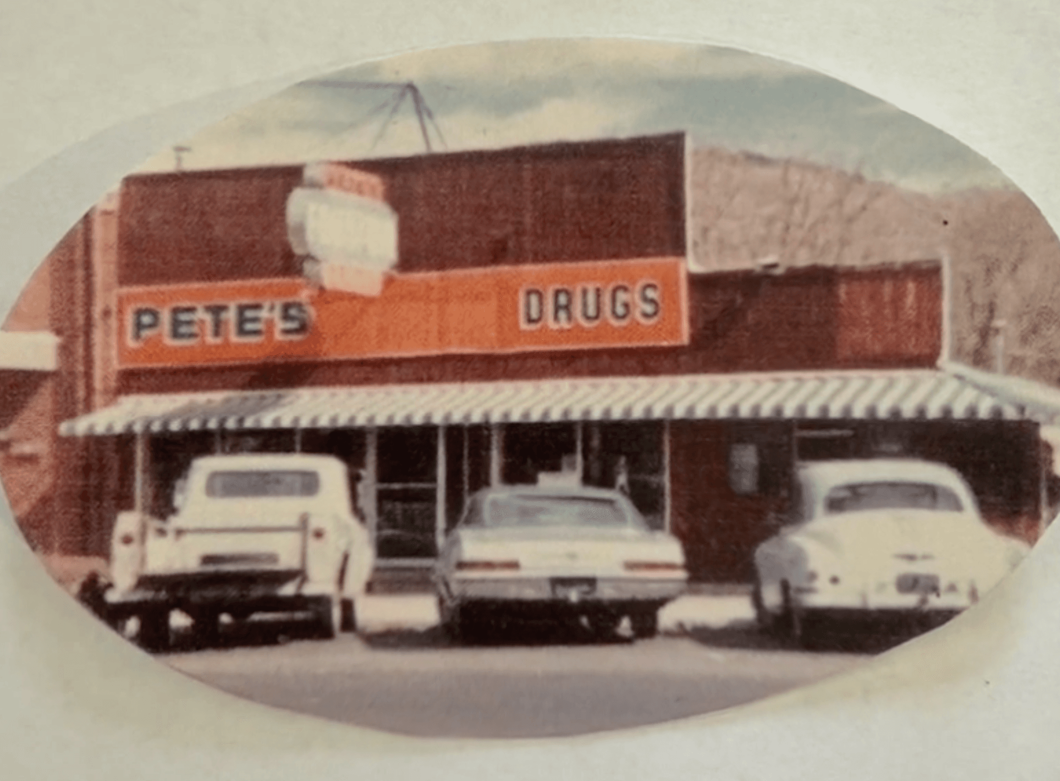 Pete's Drugs storefront with classic cars parked out front